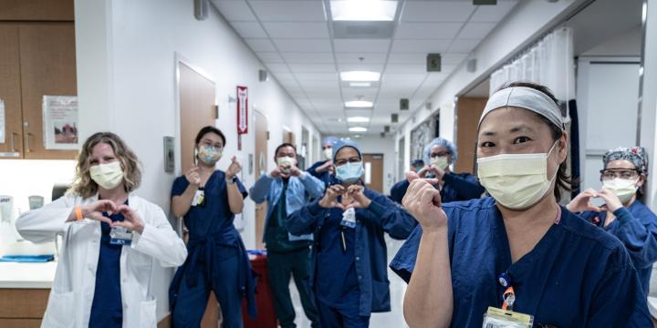 City of Hope doctor and nurses symbolling hearts with their hands in the facility hallway